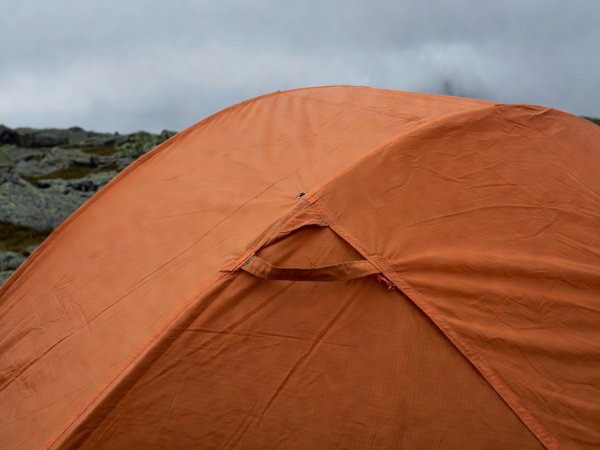 Close-up of ripstop nylon fabric and storm guyline loop on a compact two-person mountain wind sack